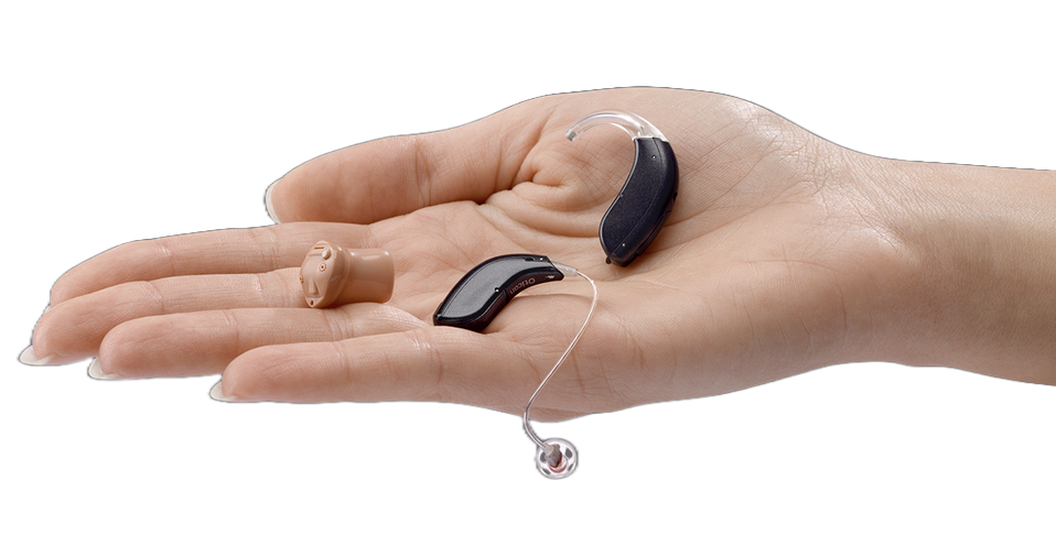 A palm holding three hearing aids — one in-the-ear and two behind-the-ear