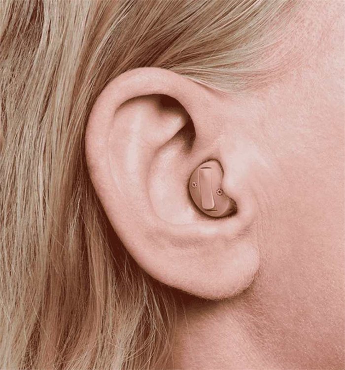 A small in-the-ear hearing aid hidden in the ear
